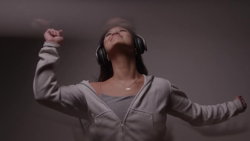 The woman is happy while listening to music on her headphones