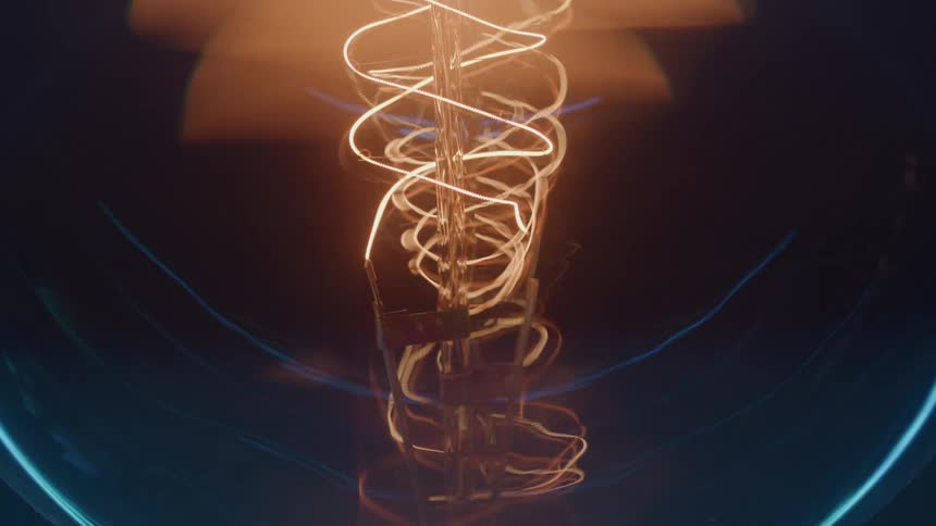 Light bulb filament lights up revealing glowing orange spirals