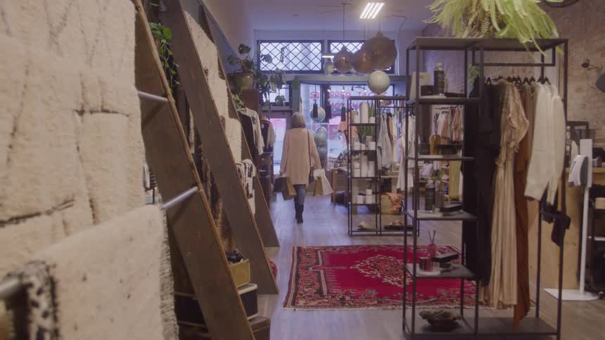 Woman walks toward the store exit carrying shopping bags