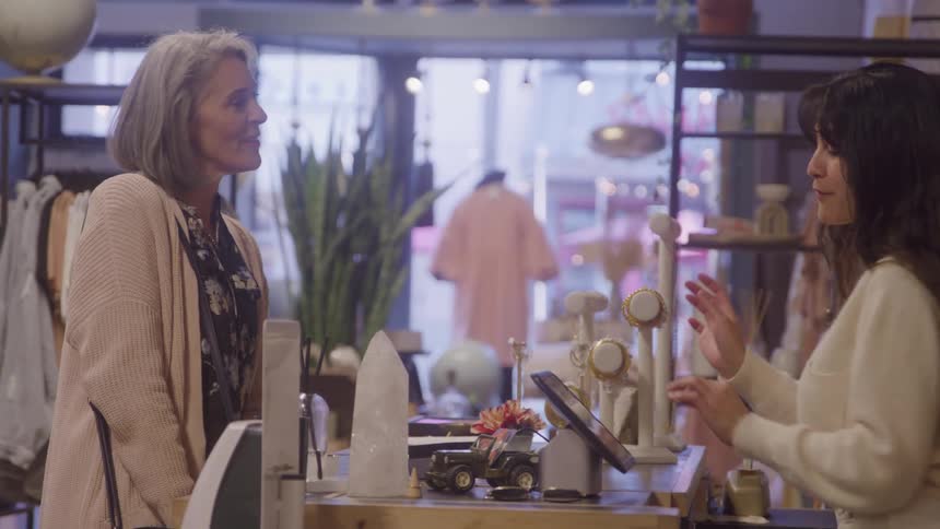 The woman talks as she pays the employee