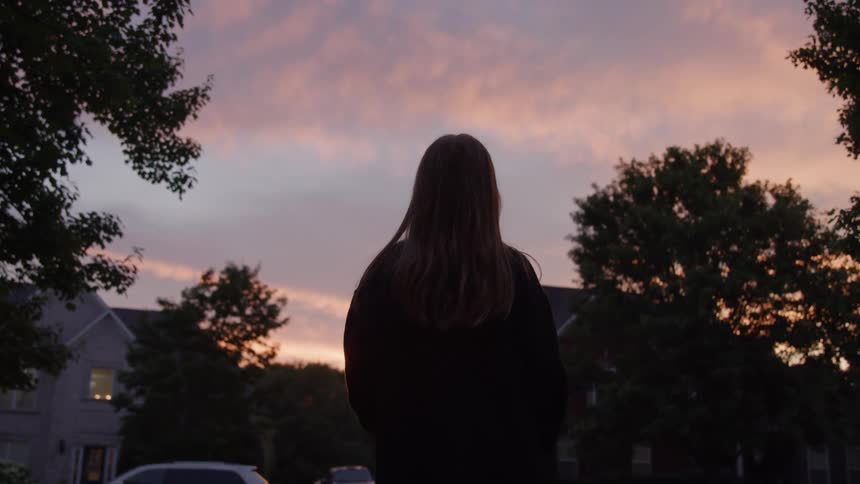 Solitary figure watching the sunset in a quiet neighborhood