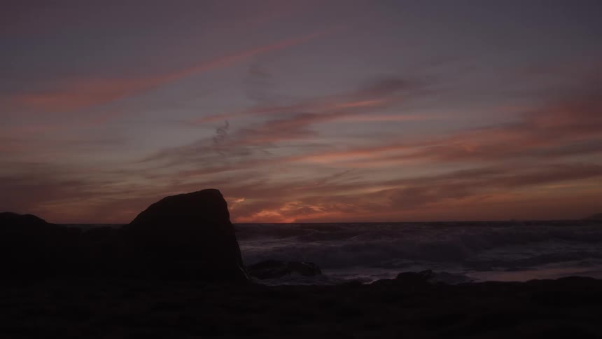 Sun sets over the sea lighting up the sky with shades of orange and purple