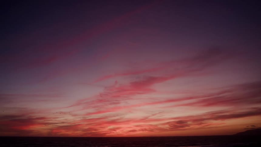 Sunlight shines on clouds in a colorful sky at dusk