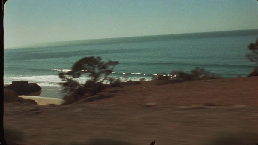 Gentle waves reach the sand beneath the calm sea horizon