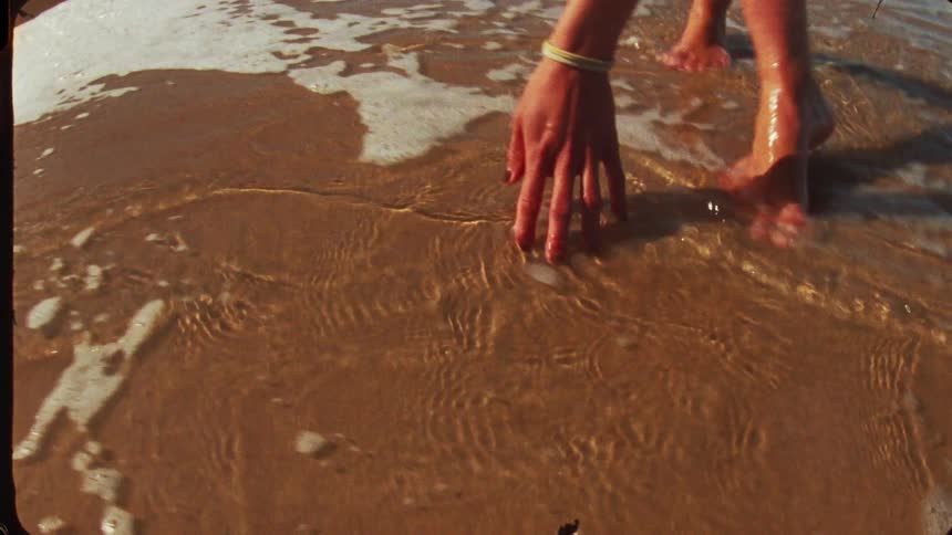 Woman on wet sand by the sea