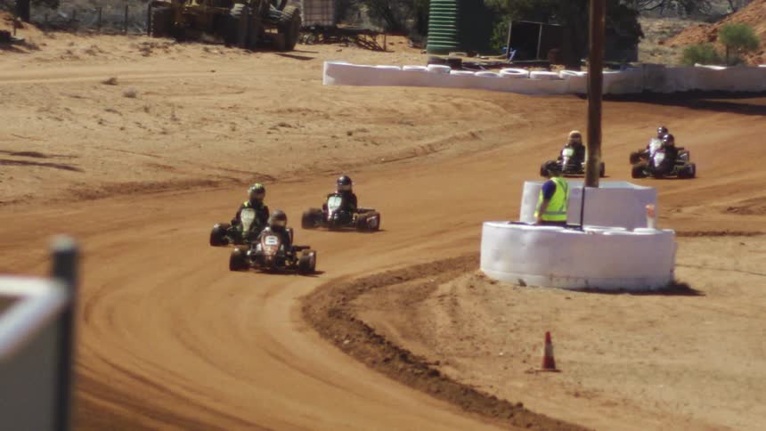 The go karts race around the dirt track