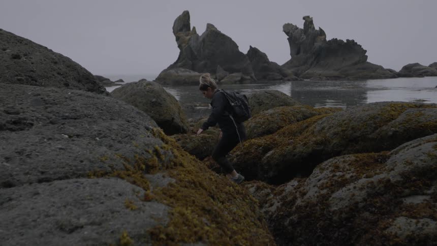 A hiker climbs on large boulders