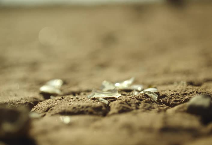 Broken glass is on the sand