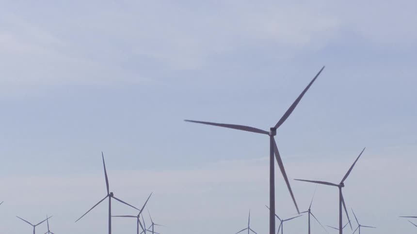 Wind turbines spin on a wind farm