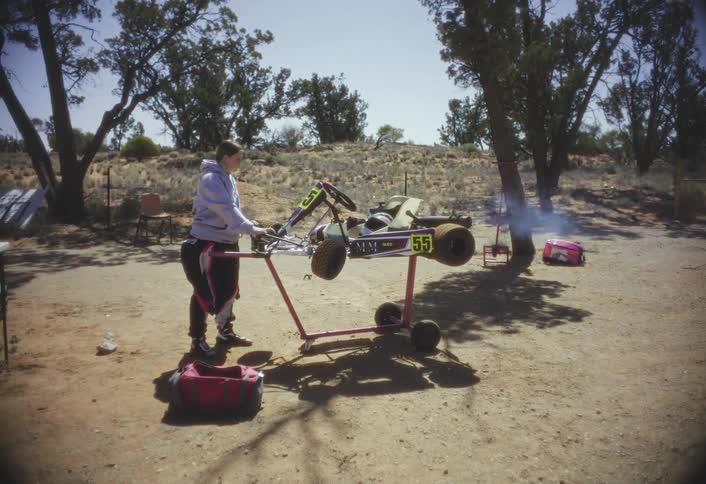 The woman is revving the go kart engine