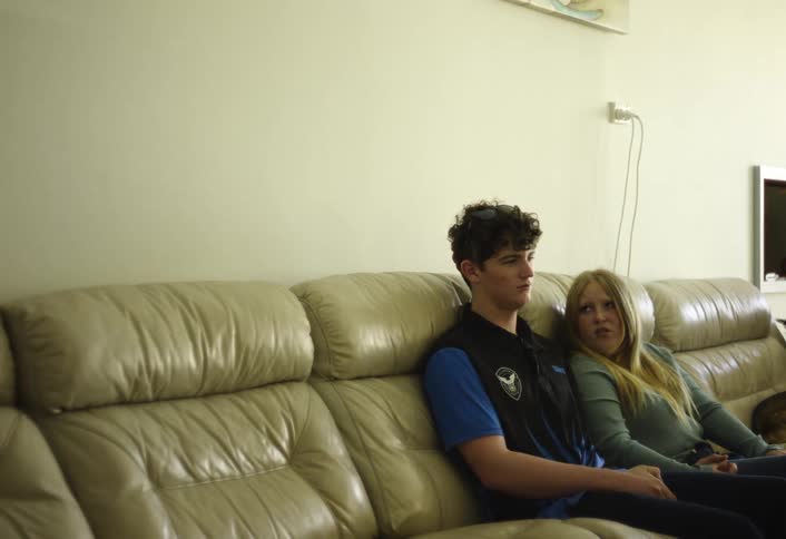 Couple sitting on the couch exchanging a serious look in a bright room