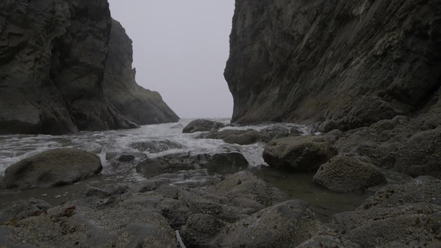 Ocean waves wash ashore a rocky beach