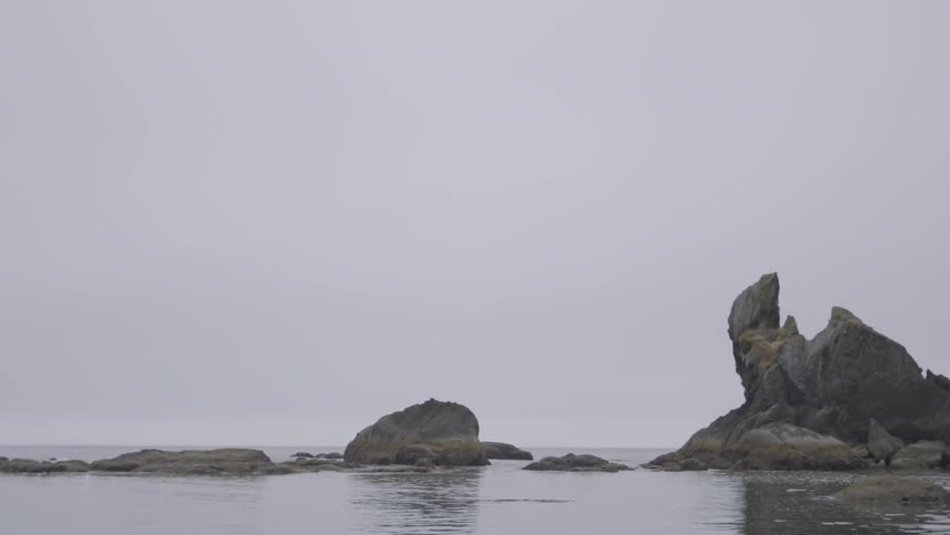 The water is calm along the rocks