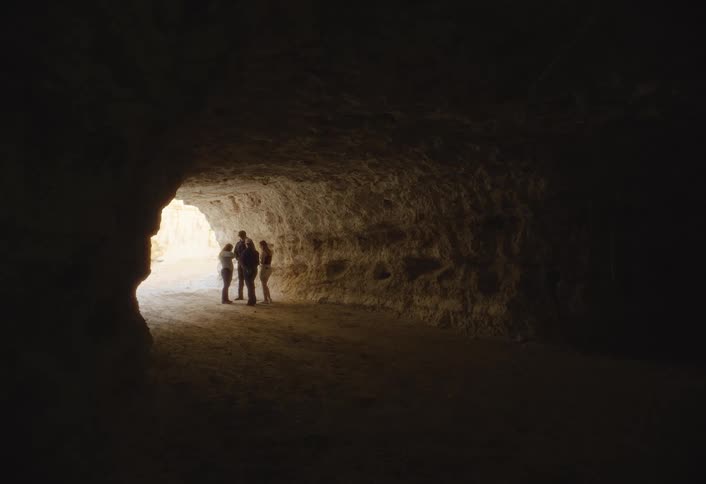 People stand at the opening of the cave