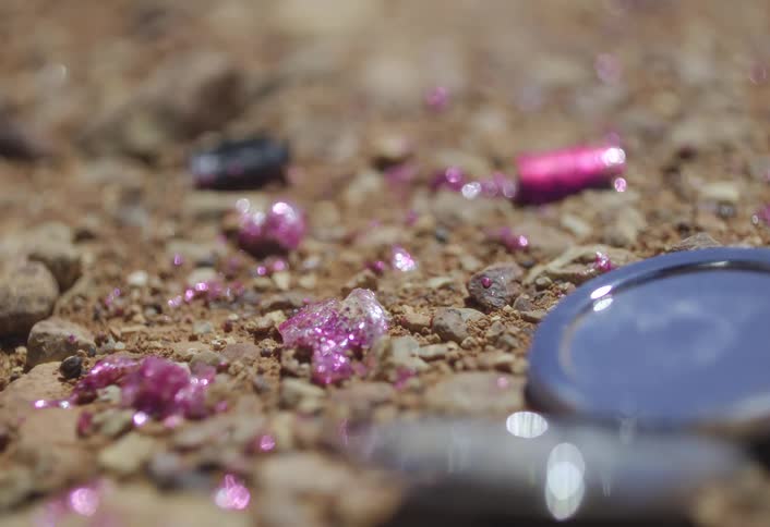 Spilled fingernail polish and a metal object lie on the ground during the daytime