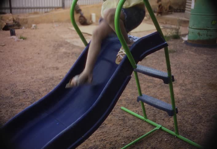 A little girl slides down a slide in the playground