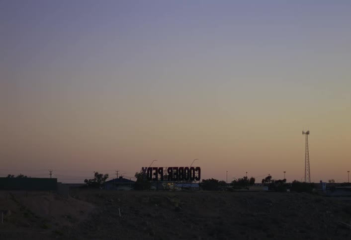 Large letters spelling out the name of the town of coober pedy stand outdoors after dusk