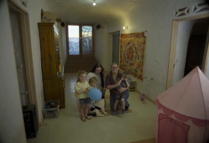 Family of five pose together with a dog in a cozy hallway