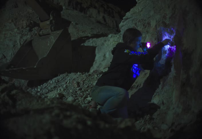 A person using a uv light to examine a cave wall