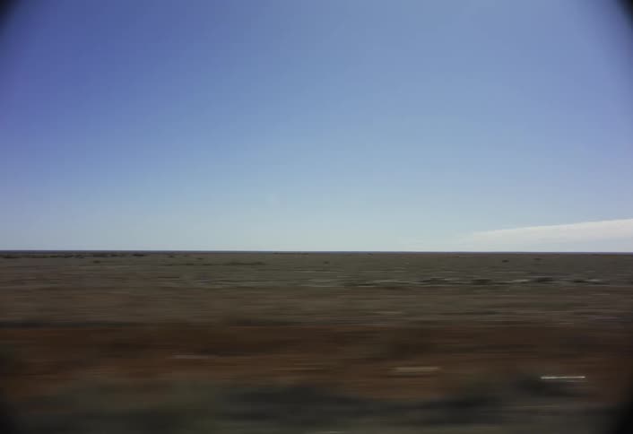 The long green field is under a clear sky
