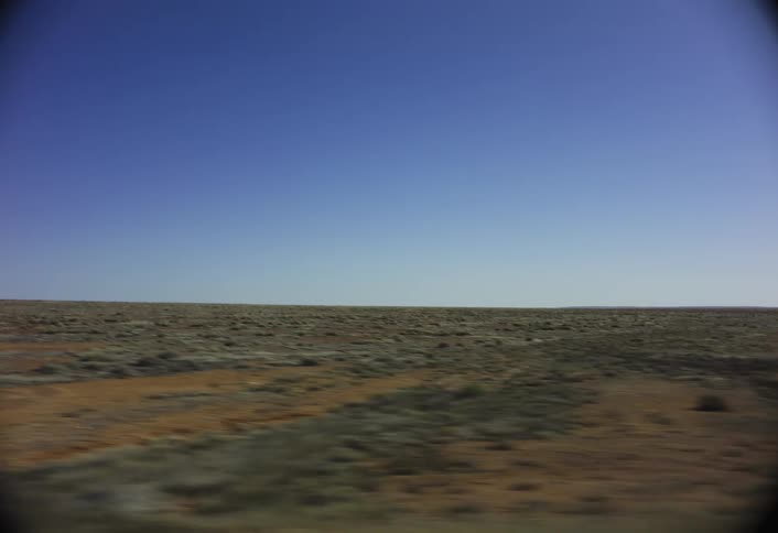 The long flat badlands are under the clear sky
