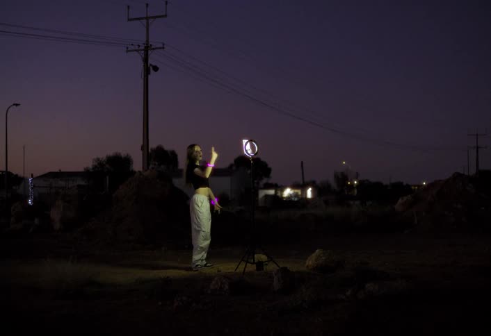 The girl records herself dancing at night in the desert