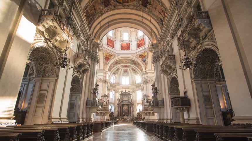 A wide shot shows the ornate interior of a grand cathedral glowing with sunlight