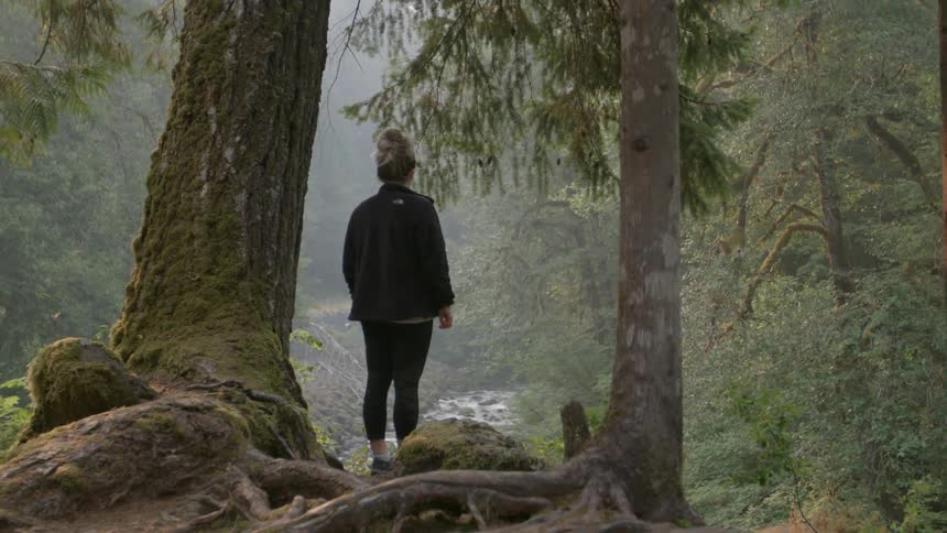 Woman standing under a tree in forest