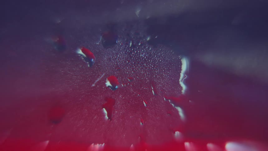 Closeup of water drops forming condensation on a foggy glass surface