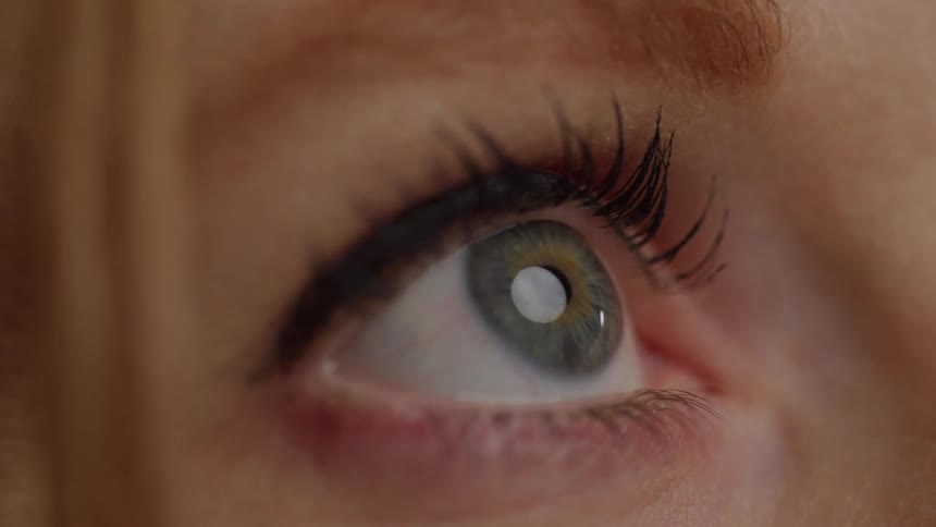 A young woman with green eyes staring at a light