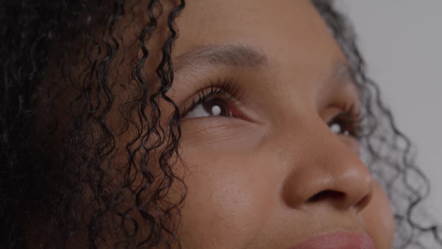 Calm gaze looking upward with focus on the eyes and curls of the hair