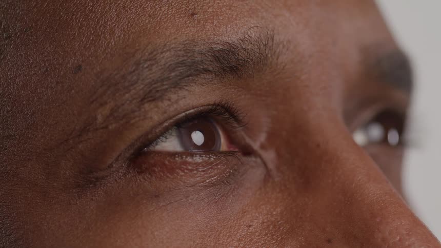 A mans eyes are shown gazing thoughtfully into the distance