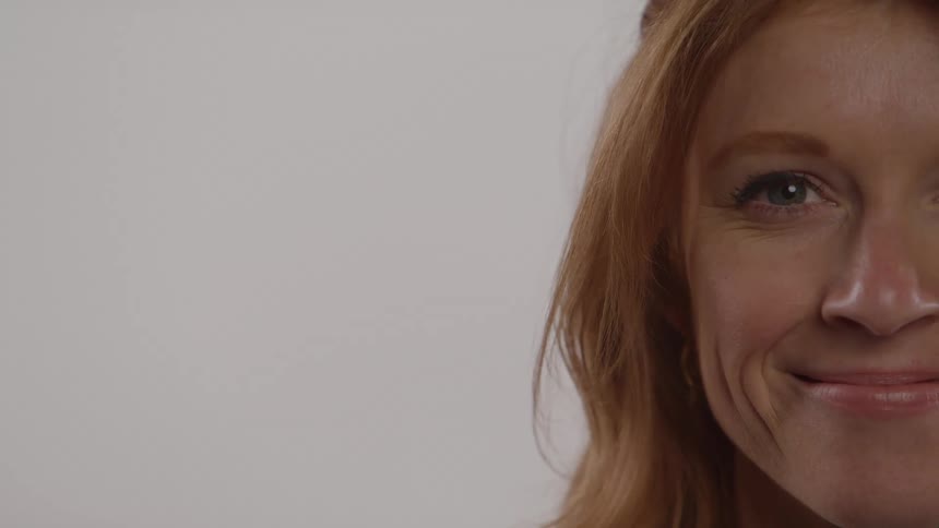 Close up partial portrait of a young happy woman in a room