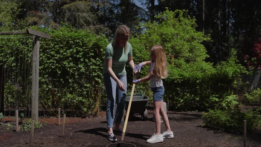 Mother and daughter high five as they garden