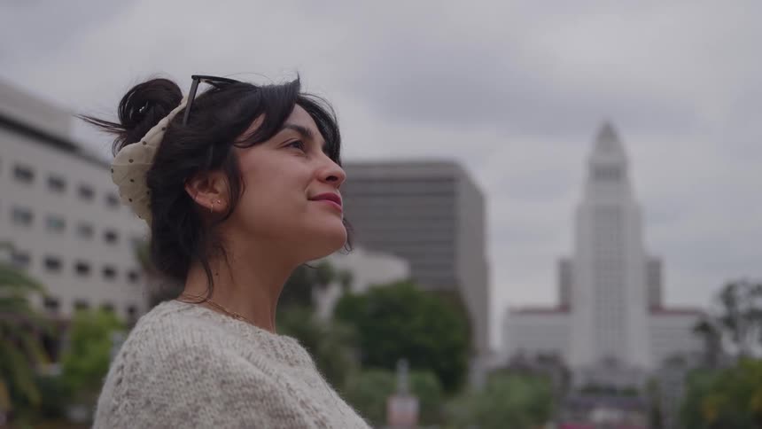 Close up portrait of a young woman standing outdoors in a metropolitan city during daytime