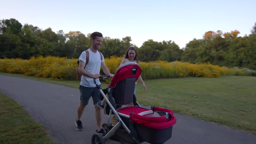 A father and mother pushing a child in a stroller