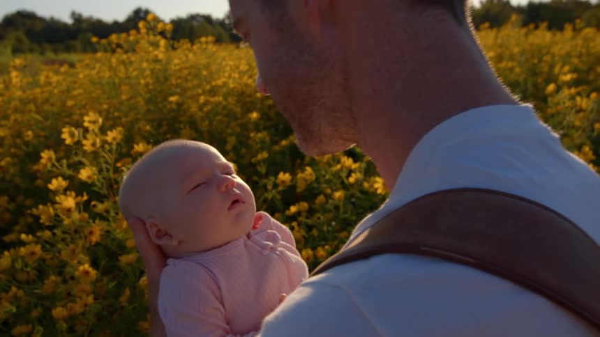 The man kisses the baby on the forehead