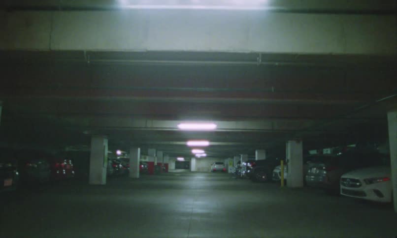 A building garage filled with multiple park vehicles at night