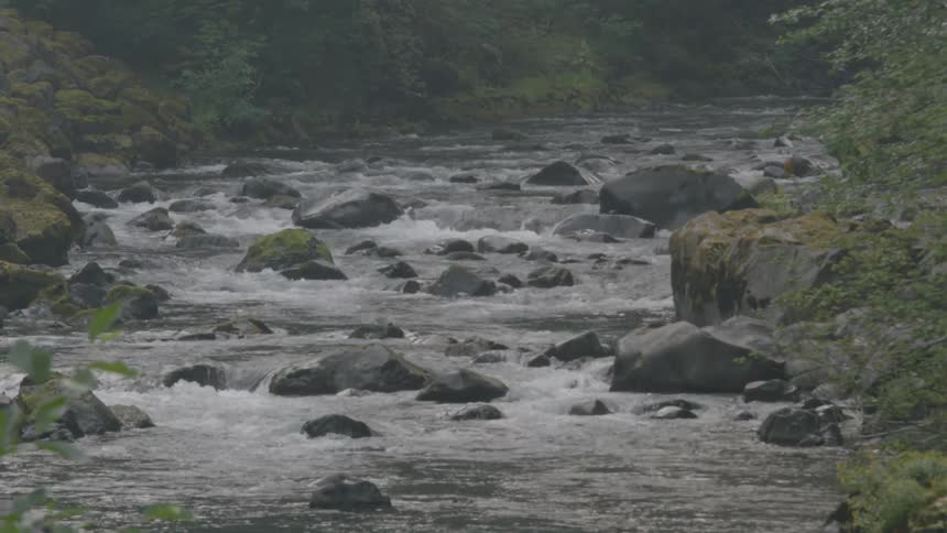 A river flows over large rocks