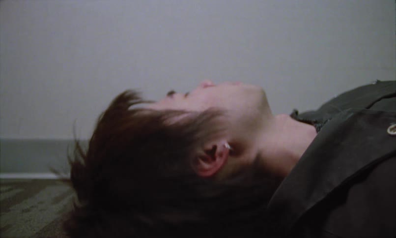 Young man lying on the floor tosses his head while dreaming
