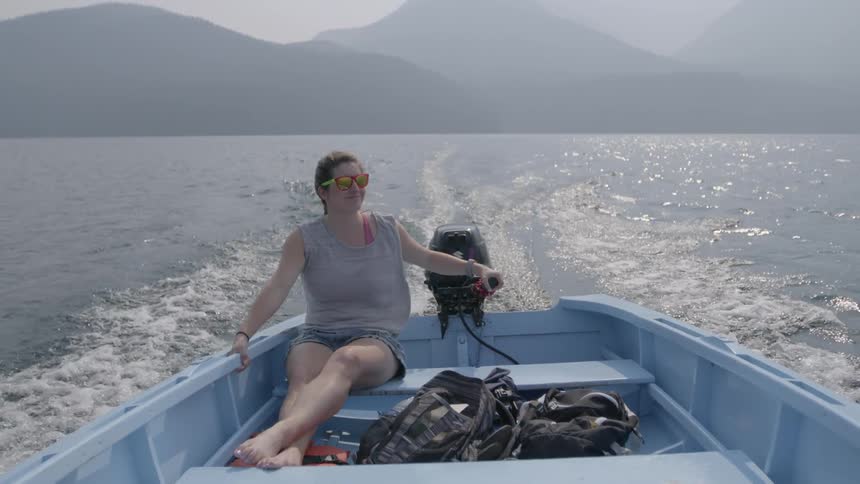 A woman steers the boat with the tiller