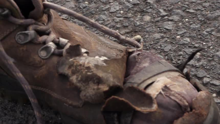 An old, abandoned boot sits on the ground