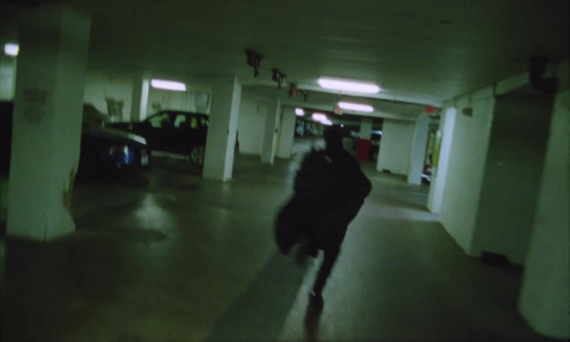 Person runs in an underground parking garage lit by artificial light