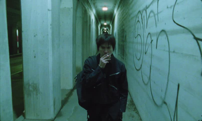 A man is walking and smoking at night