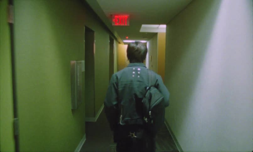 Person walks through a lit hallway toward the emergency exit