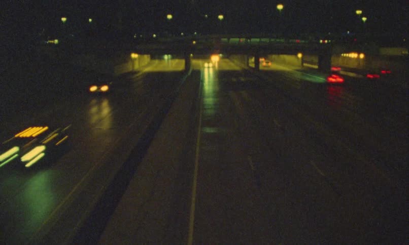 Empty freeway at night with street lights and cars