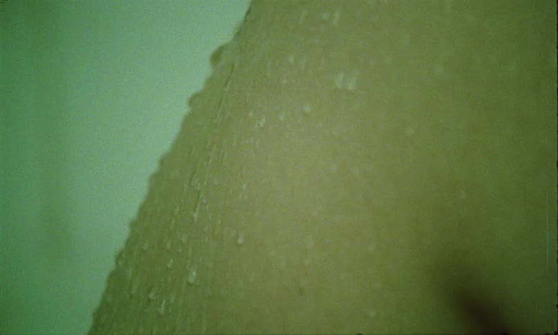The skin of a part of a persons body that has drops of water falling on it