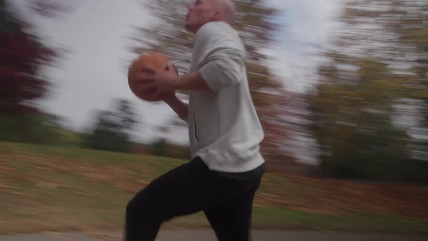 The man dribbles and shoots the basketball