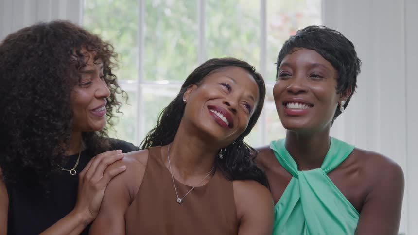 Three women laugh and talk together