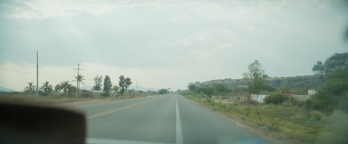 A car driving on a countryside road at midday